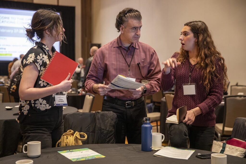 Three people talking at conference